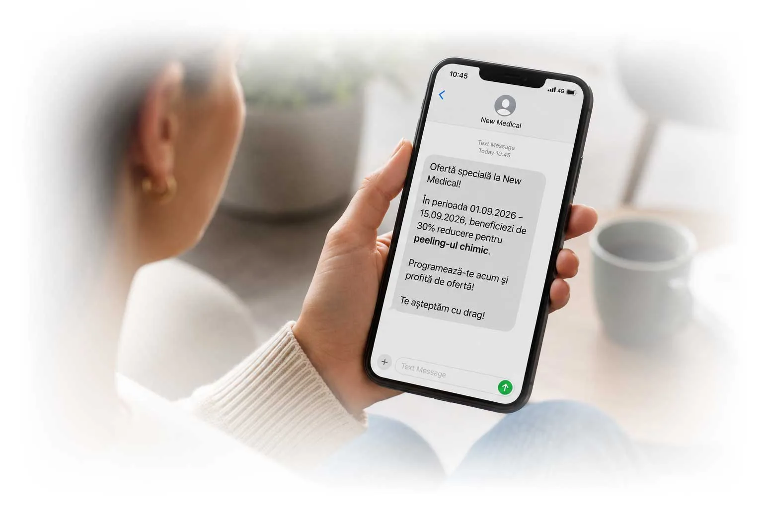 Persoană citind pe telefon un SMS promoțional automat trimis prin Evolvo, cu o ofertă specială a clinicii — exemplu de comunicare prin notificări push și mesaje personalizate.